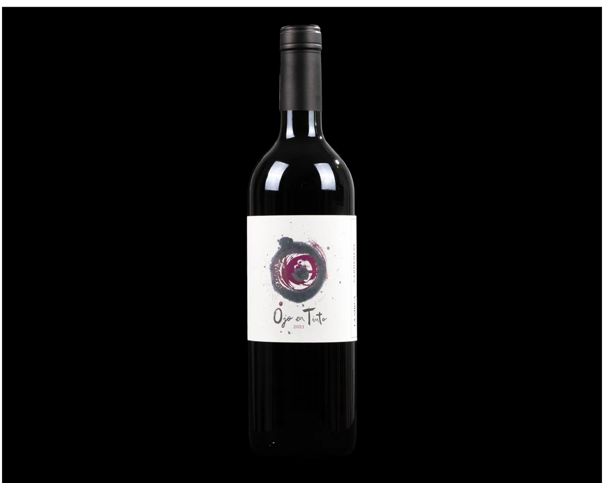 Botella de vino tinto Ojo en Tinto Carmenere de La Sirca Boutique Winery con etiqueta artística sobre fondo negro